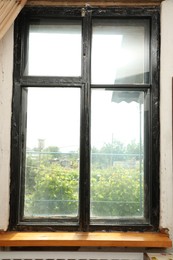 Photo of Old window with empty wooden sill in room