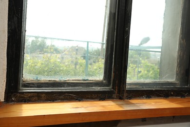 Photo of Old window with wooden sill in room