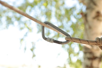 Photo of Screw lock carabiner with rope on cable outdoors
