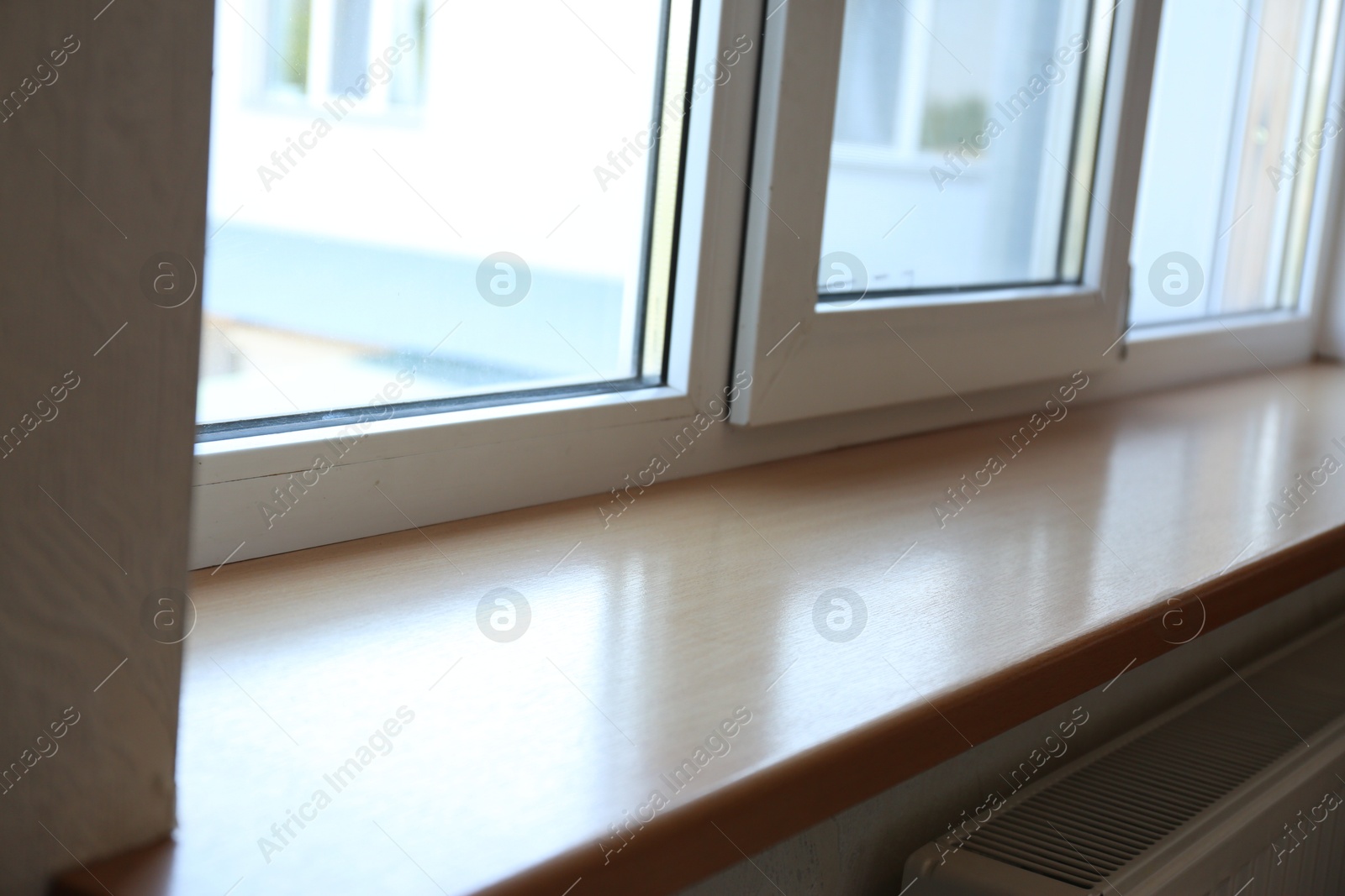 Photo of Closeup of plastic window with wooden sill