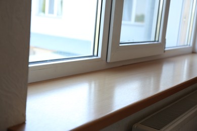 Photo of Closeup of plastic window with wooden sill