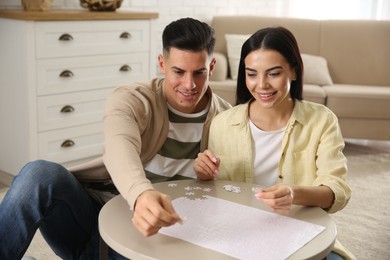 Photo of Happy couple playing with puzzles at home
