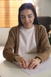 Photo of Young woman playing with puzzles at home