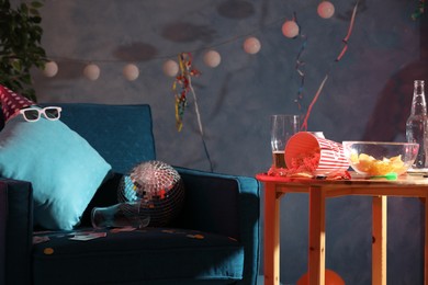Photo of Wooden table and armchair in messy room after party