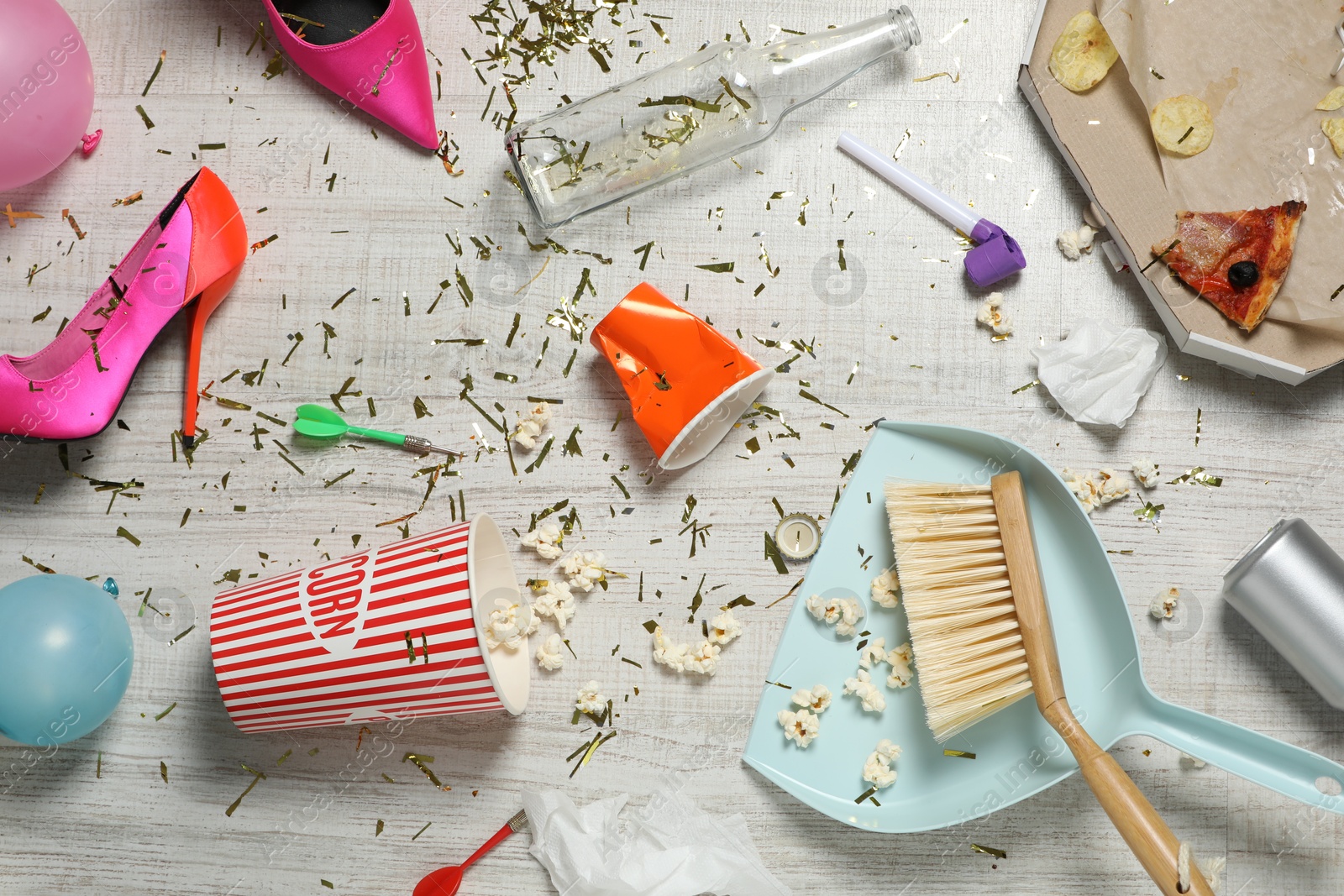 Photo of Brush and dustpan on messy floor after party, flat lay