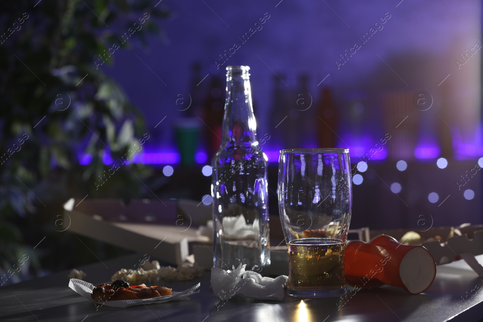 Photo of Messy table with beer and food leftovers indoors, space for text. After party chaos
