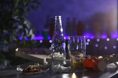 Photo of Messy table with beer and food leftovers indoors, space for text. After party chaos