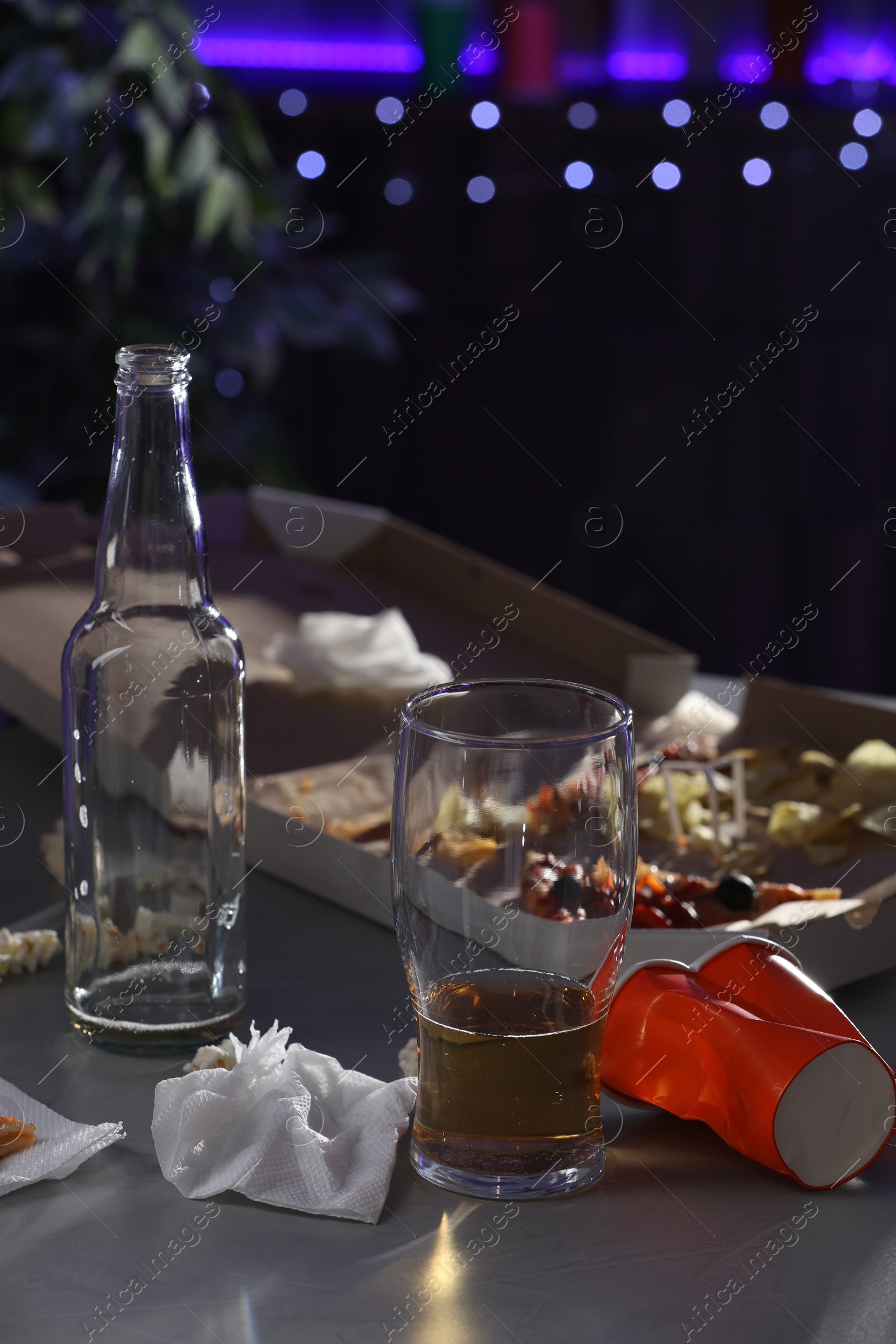 Photo of Messy table with beer and food leftovers indoors. After party chaos