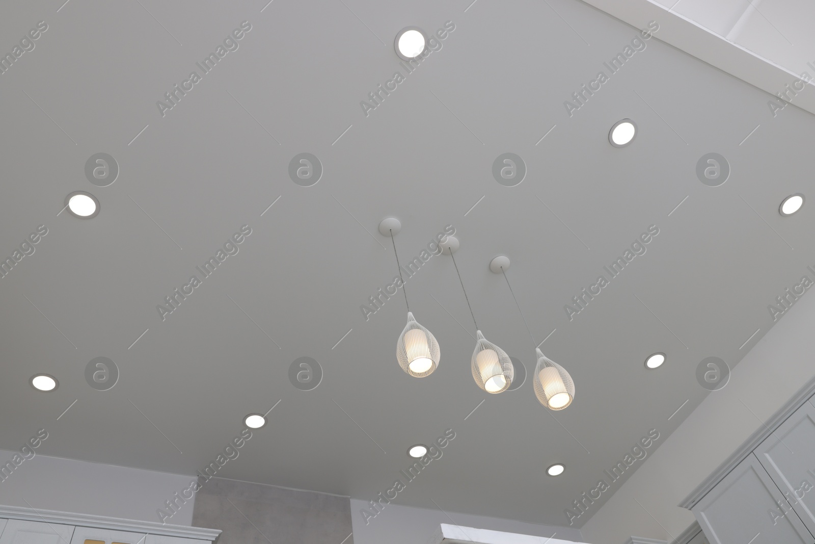 Photo of Ceiling with modern lamps in renovated stylish room, low angle view
