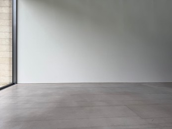 Photo of Empty room with white wall and grey floor