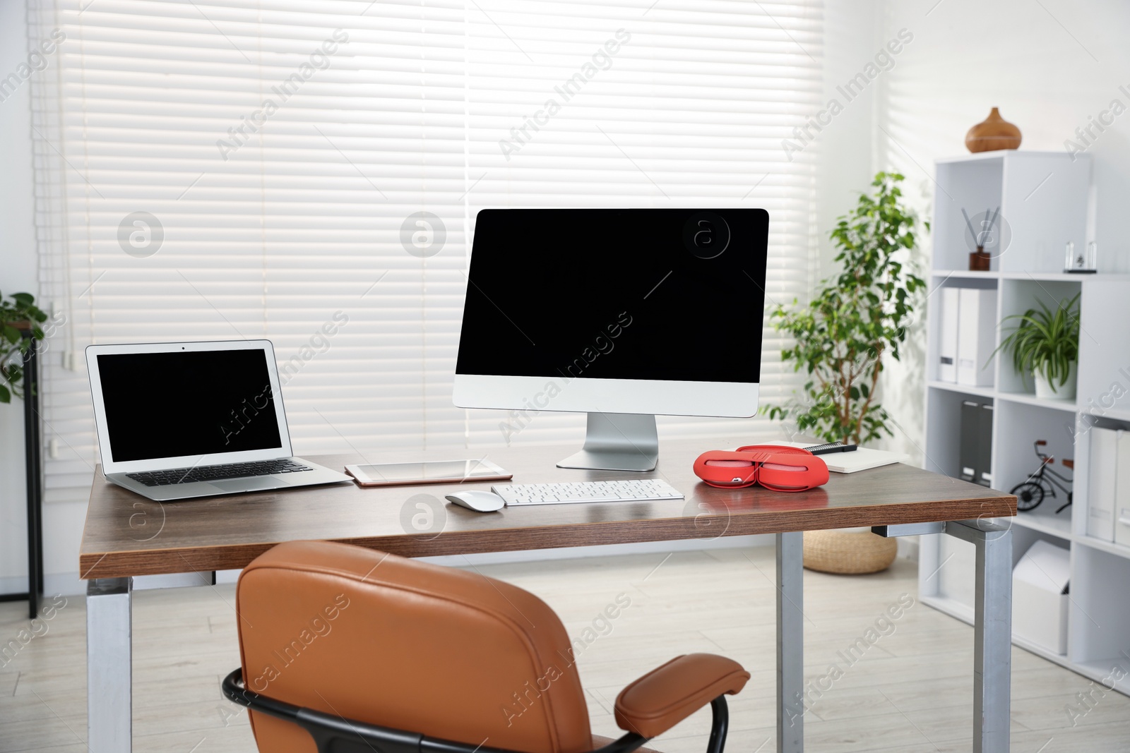 Modern workplace with computer, laptop, tablet and headphones on wooden desk in office Photo of Modern workplace with computer, laptop, tablet and headphones on wooden desk in office