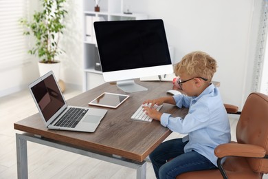 Photo of Choice of profession. Little boy pretending to work in office