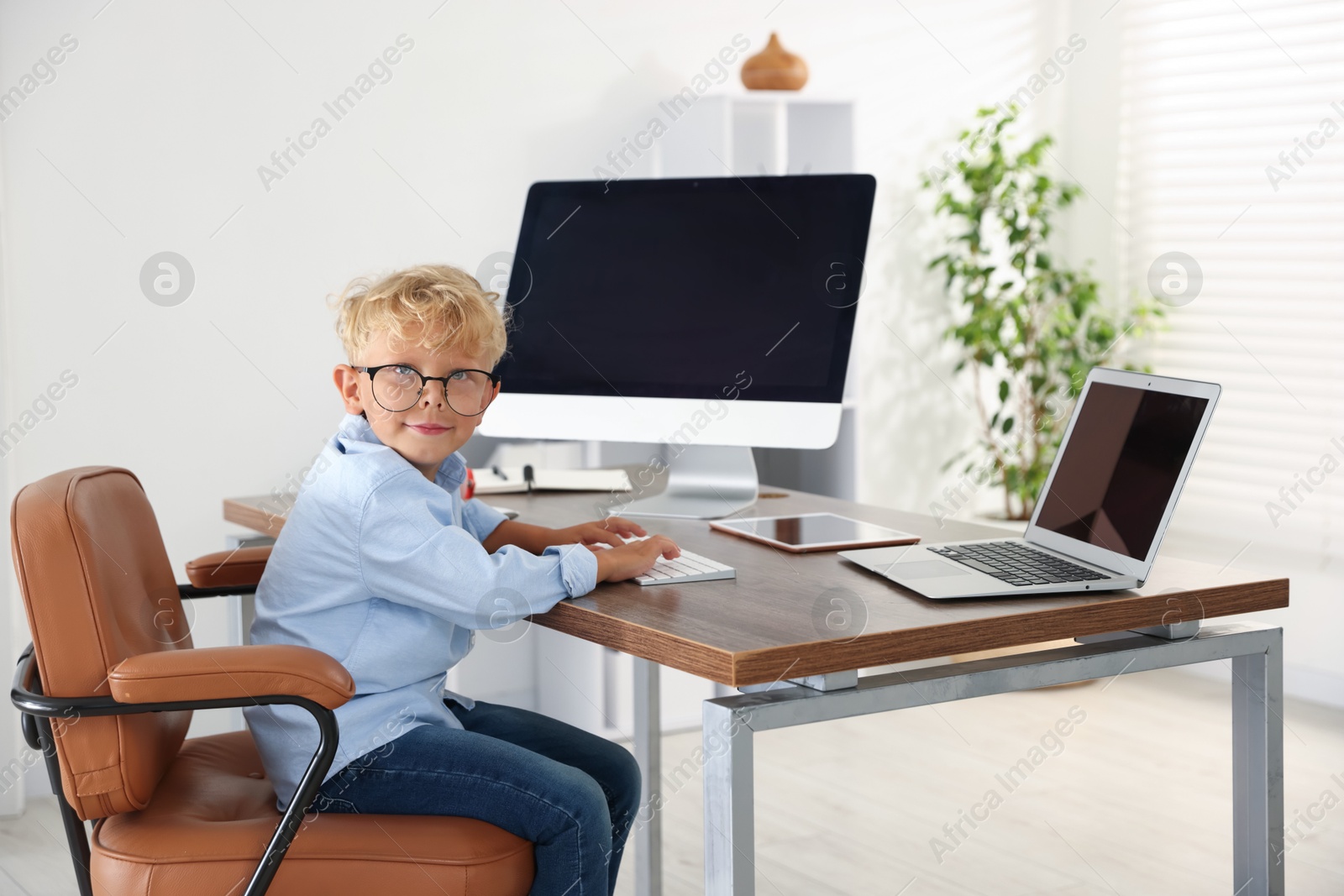 Photo of Choice of profession. Little boy pretending to work in office
