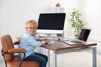 Photo of Choice of profession. Little boy pretending to work in office