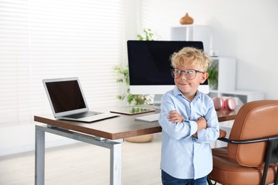 Photo of Choice of profession. Little boy pretending to work in office