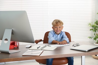 Photo of Choice of profession. Little boy pretending to work on computer in office