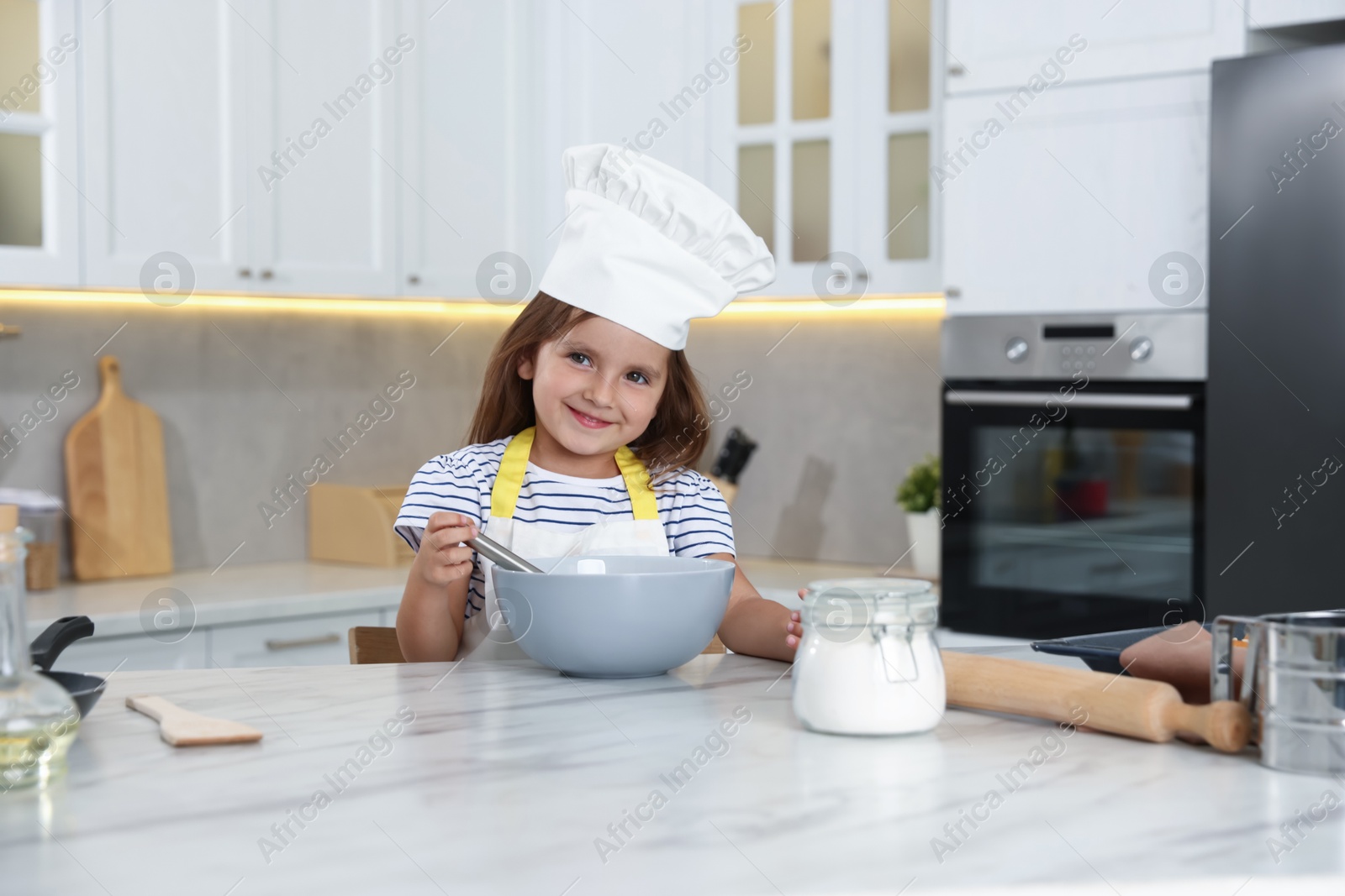 Photo of Choice of profession. Little girl pretending to be chef in kitchen