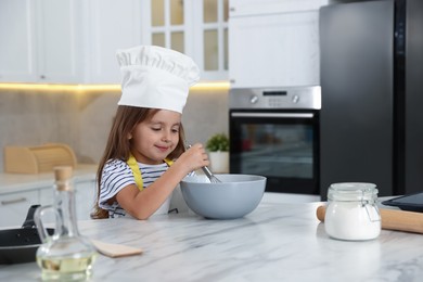 Photo of Choice of profession. Little girl pretending to be chef in kitchen