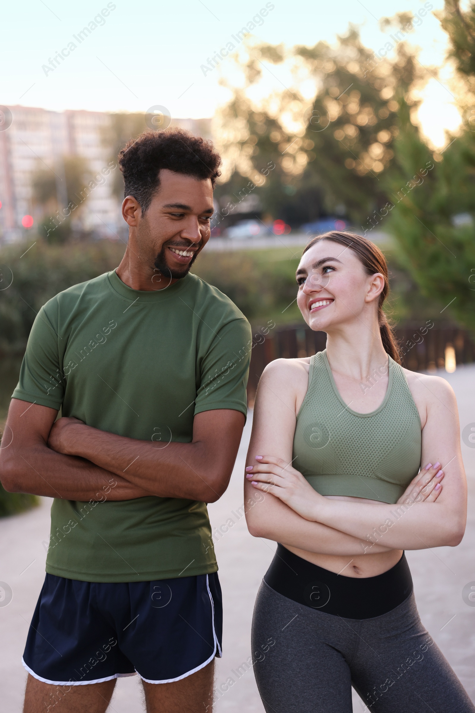 Smiling runners posing with crossed arms outdoors Photo of Smiling runners posing with crossed arms outdoors