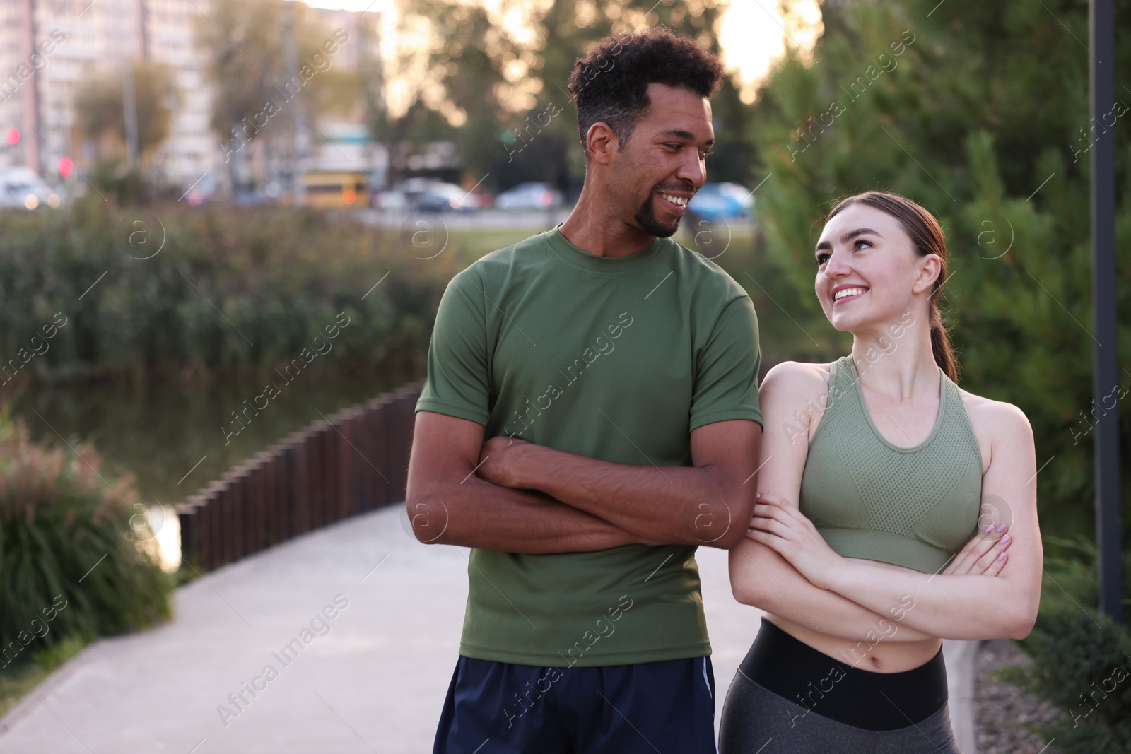 Smiling runners posing with crossed arms outdoors. Space for text Photo of Smiling runners posing with crossed arms outdoors. Space for text
