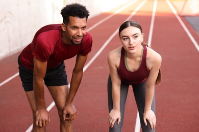 Photo of Smiling couple resting after run at stadium