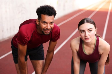 Photo of Smiling couple resting after run at stadium
