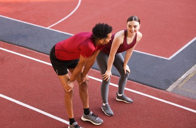 Photo of Smiling couple resting after run at stadium