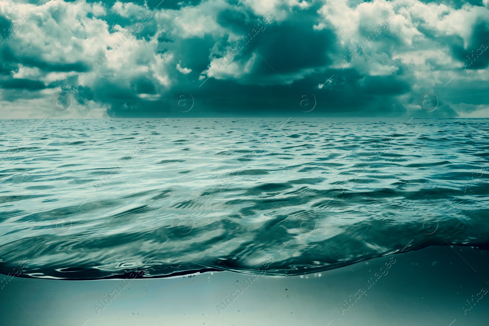 Image of Sea water surface and underwater view. Cloudy sky above