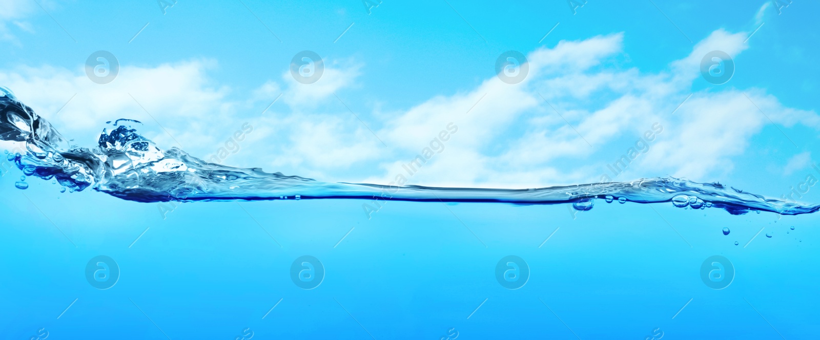 Image of Sea water surface and underwater view. Sky with clouds above