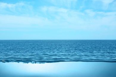 Image of Sea water surface and underwater view. Sky with clouds above