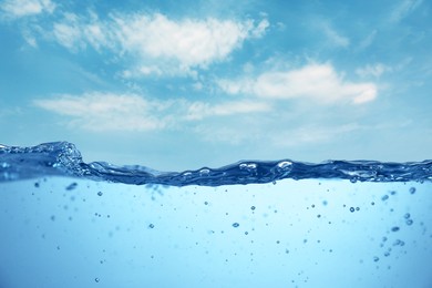 Image of Sea water surface and underwater view. Sky with clouds above