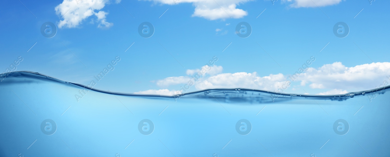 Image of Sea water surface and underwater view. Sky with clouds above