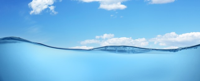 Image of Sea water surface and underwater view. Sky with clouds above