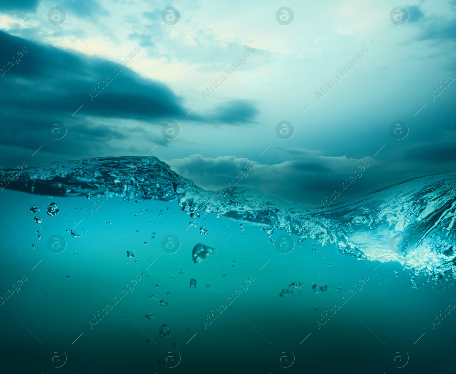 Image of Sea water surface and underwater view. Cloudy sky above