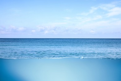 Image of Sea water surface and underwater view. Sky with clouds above