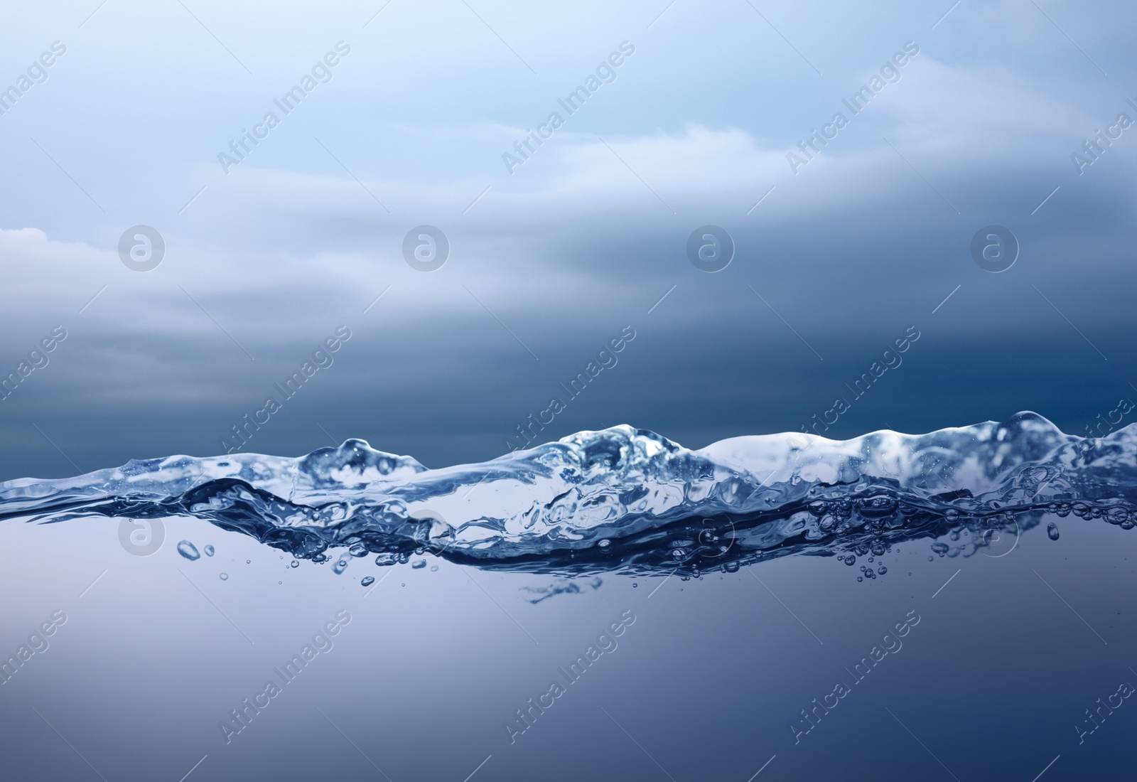Image of Sea water surface and underwater view. Cloudy sky above