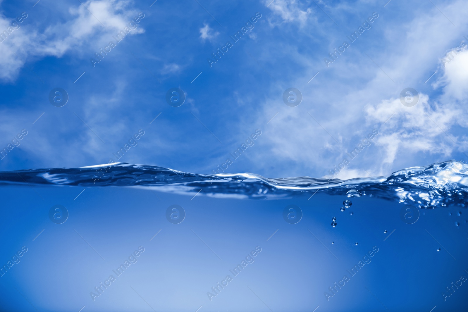 Image of Sea water surface and underwater view. Sky with clouds above