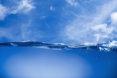 Image of Sea water surface and underwater view. Sky with clouds above
