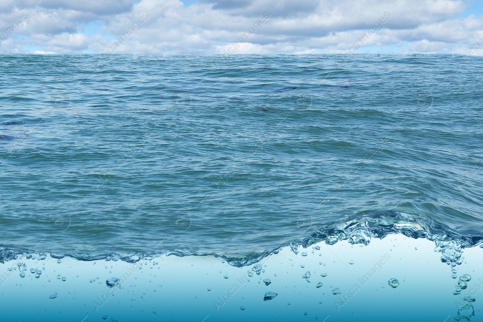 Image of Sea water surface and underwater view. Sky with clouds above