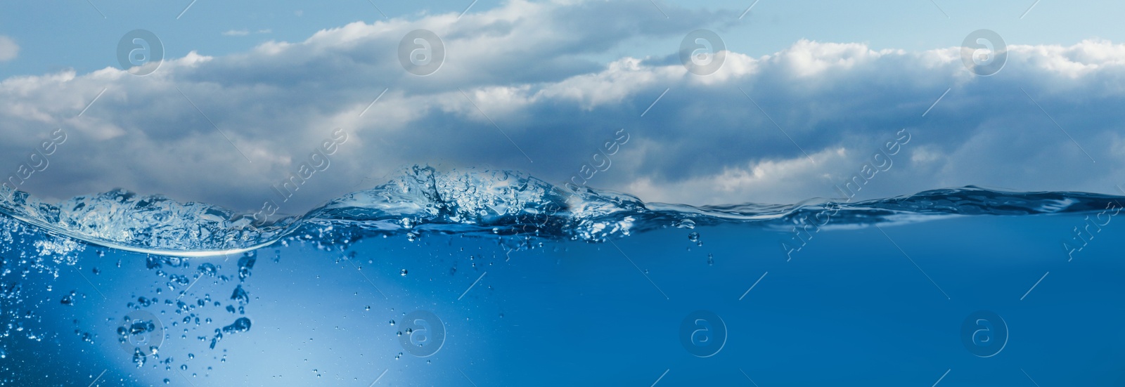 Image of Sea water surface and underwater view. Sky with clouds above