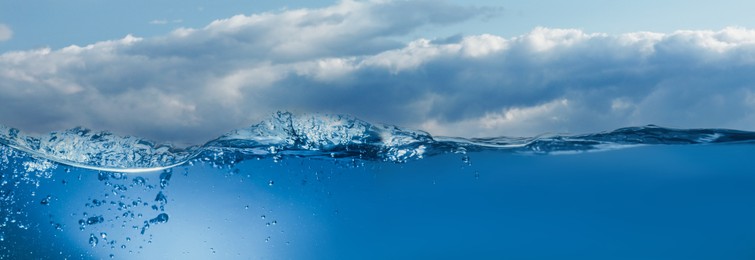Image of Sea water surface and underwater view. Sky with clouds above