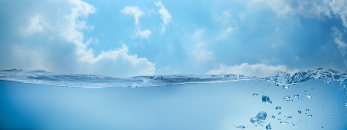 Image of Sea water surface and underwater view. Sky with clouds above