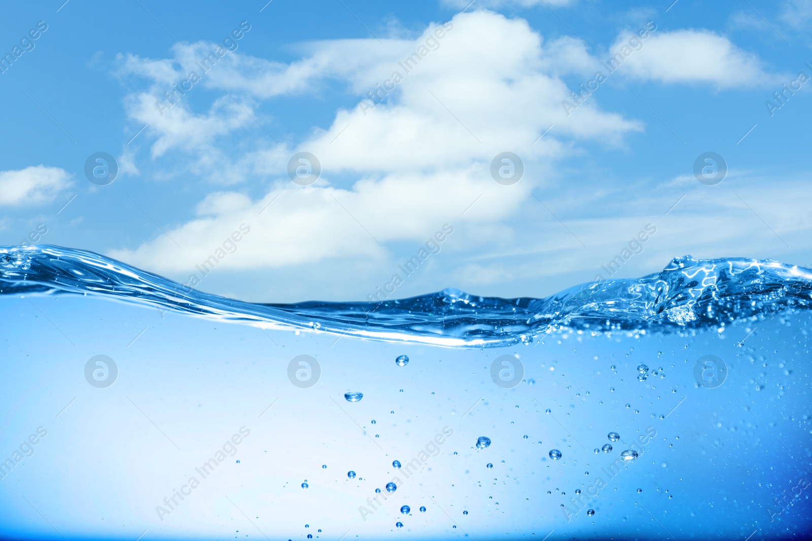 Image of Sea water surface and underwater view. Sky with clouds above