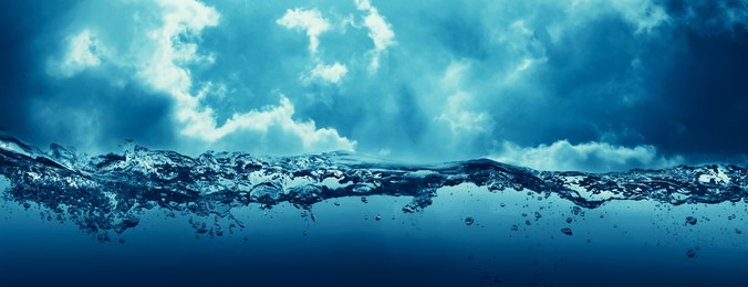 Image of Sea water surface and underwater view. Sky with clouds above