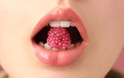 Photo of Woman with beautiful lips makeup and raspberry candy, closeup