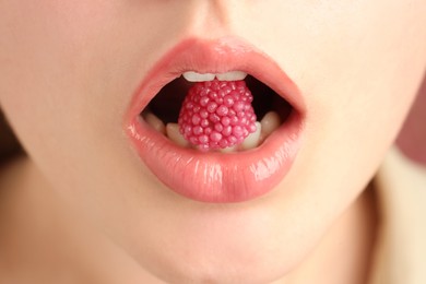 Photo of Woman with beautiful lips makeup and raspberry candy, closeup