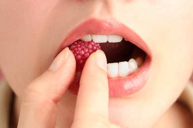 Photo of Woman with beautiful lips makeup and raspberry candy, closeup