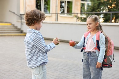 Photo of Cute kids with apples outdoors. School lunch