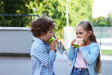 Photo of Cute kids eating food outdoors. School lunch