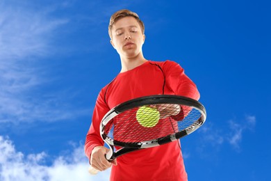 Image of Man playing tennis against blue sky with clouds, low angle view